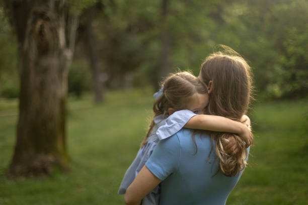 istock Mother and daughter sharing a tender embrace in a tranquil park. 2155521830