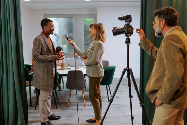 istock African American businessman being interviewed by journalists at work 2155523113