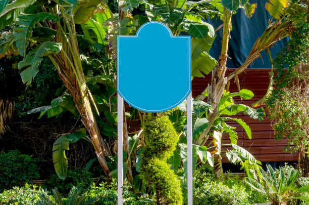 Blue empty billboard on a city street surrounded by trees. Clipping path mockup template