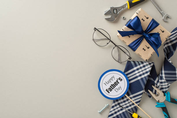 istock This image showcases a Father's Day theme with a beautifully wrapped gift, tools, a necktie, and glasses, symbolizing a celebration for dads 2155526497