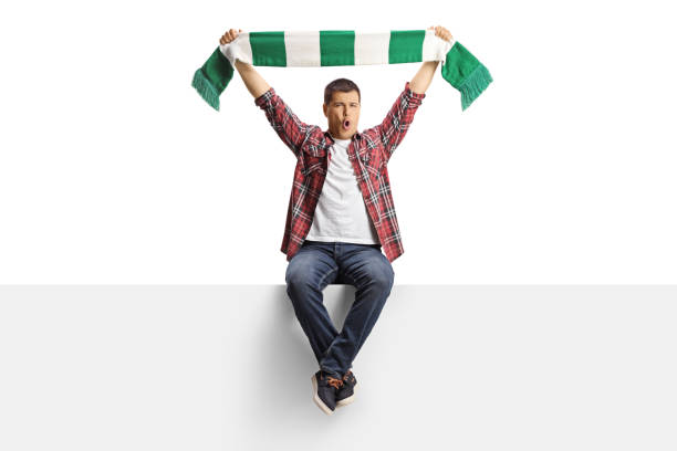 istock Excited man sitting on a panel and cheering with a scarf 2155527017