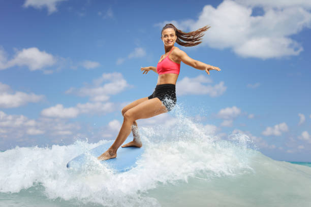 istock Female surfer riding a surfboard on a wave 2155527018