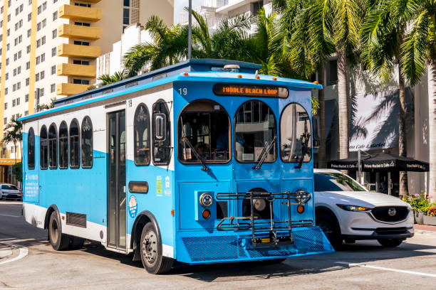 Miami, USA - March 19, 2017 : Green trolley in the traffic on Downtown Miami street. Miami Trolley provides free transportation in the city.