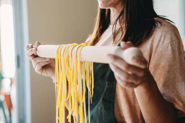 istock A woman is holding a rolling pin with tagliatelle hanging down 2155529073