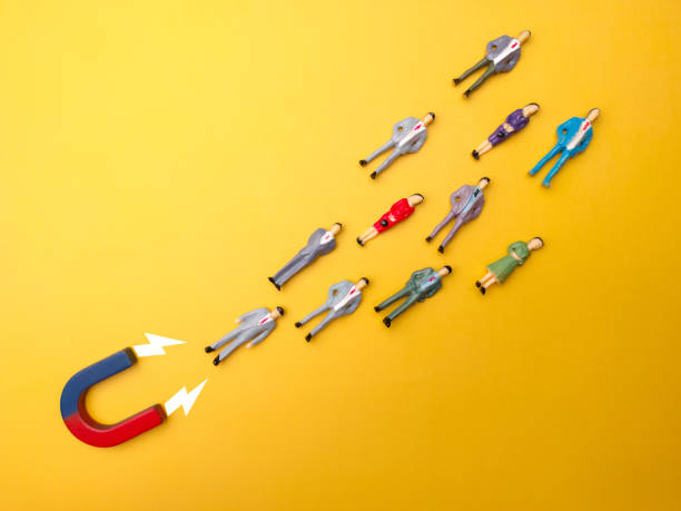 istock Businessman attracts by magnet on a yellow background 2155529239