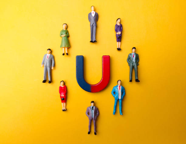 istock Businessman attracts by magnet on a yellow background 2155529249