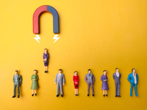 istock Businessman attracts by magnet on a yellow background 2155529484