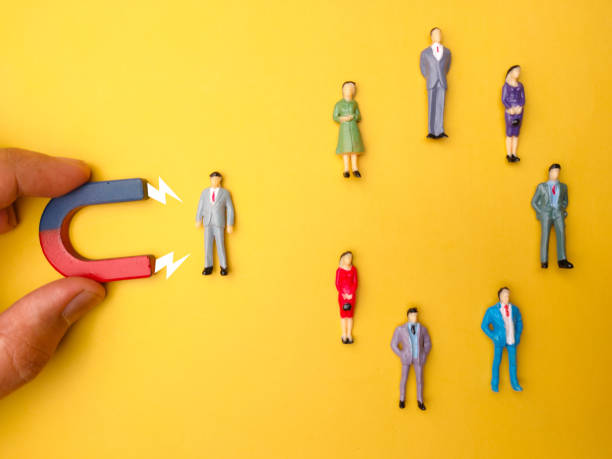 istock Businessman attracts by magnet on a yellow background 2155529571