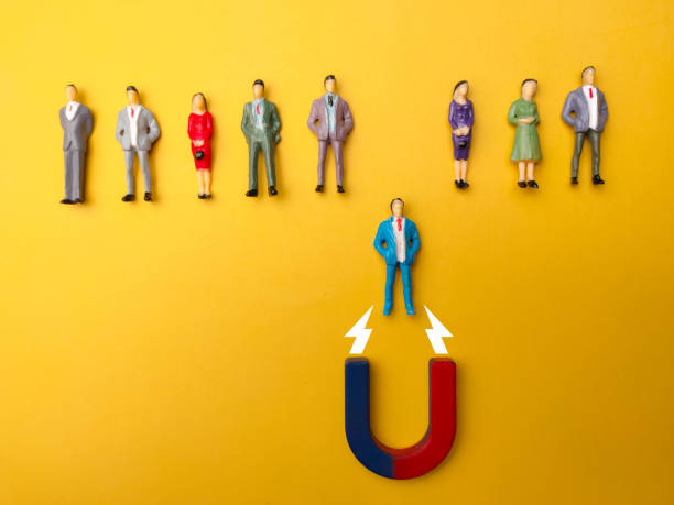 istock Businessman attracts by magnet on a yellow background 2155529577