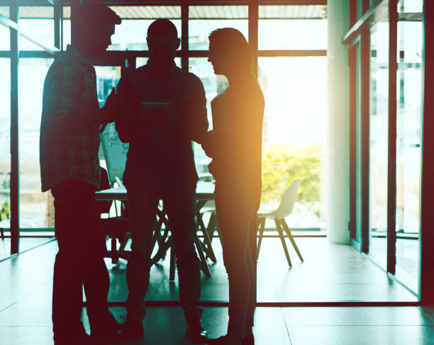 istock Business people, office and silhouette with collaboration, teamwork and company communication. Meeting, staff and public relations employee with networking, conversation and lens flare at workplace 2155530307