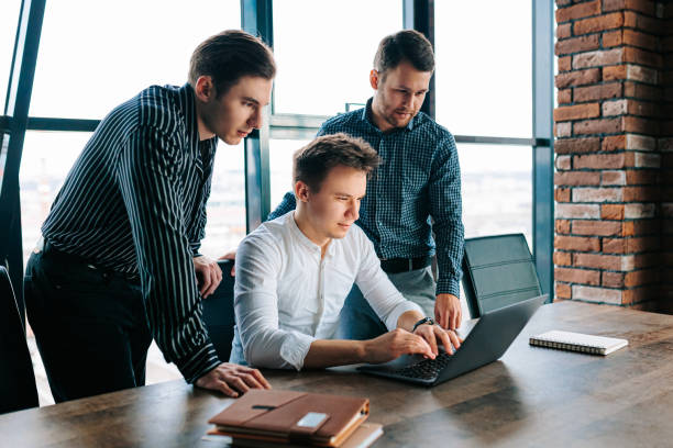 istock Businessmen using their laptops to discuss strategy in a team meeting. 2155530566