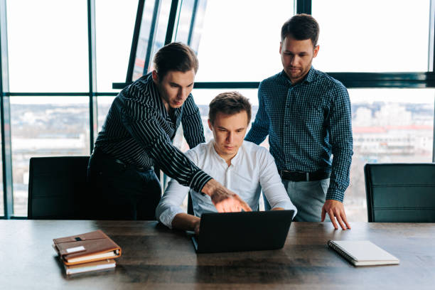 istock Professionals using their laptops to conduct business in an office setting. 2155530573