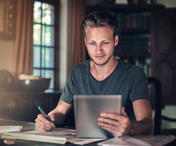 istock Elearning, paper or man with tablet in home office for planning, research or homework, project or assignment. Business course, study and architect student with digital search for blueprint compliance 2155531912