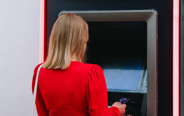 istock Woman using ATM on the street. 2155531949
