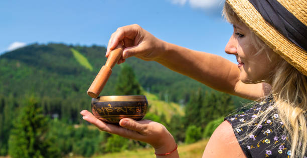 istock A woman holds a singing bowl in her hands. Selective focus. 2155533740