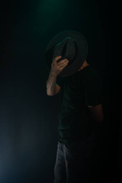 istock Mysterious, bearded man wearing a hat posing for the camera. Studio portrait. 2155534329