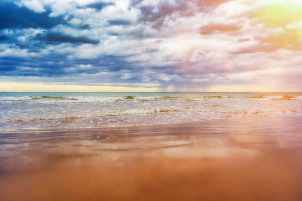 Sun flare through overcast clouds and a storm out to sea
