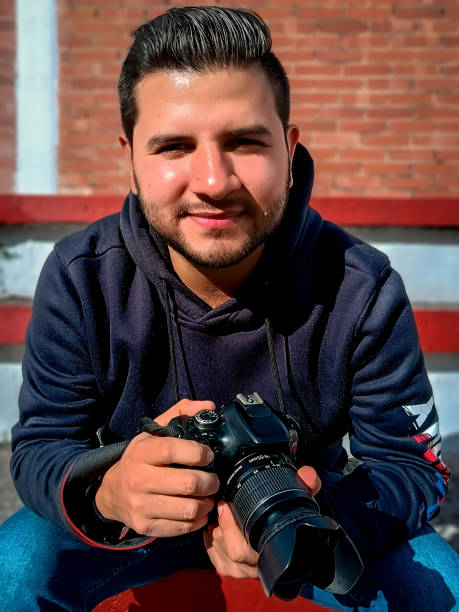 istock young latino photographer with camera in hand from front 2155536530
