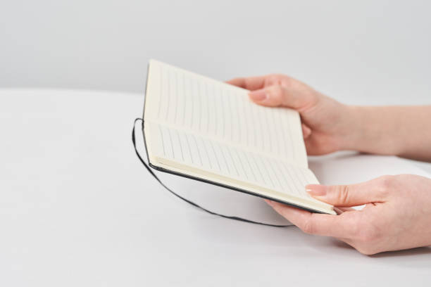 istock Hand of a woman holding a notepad 2155545974