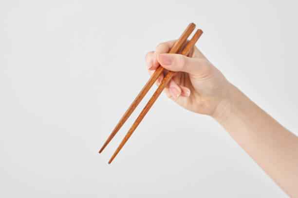 istock Hand of a woman holding chopsticks 2155545996