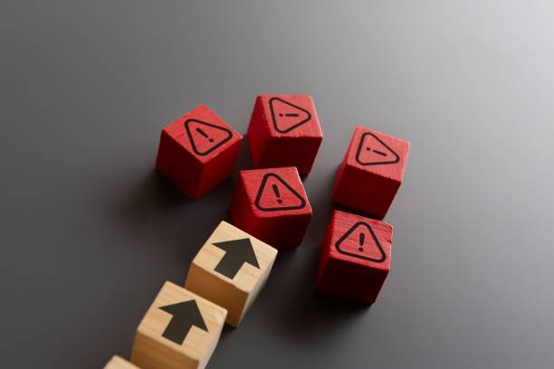 istock Wooden blocks with upward arrow and warning icon. 2155546261