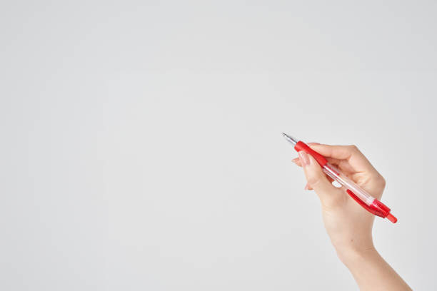 istock female hand holding red ballpoint pen 2155546669
