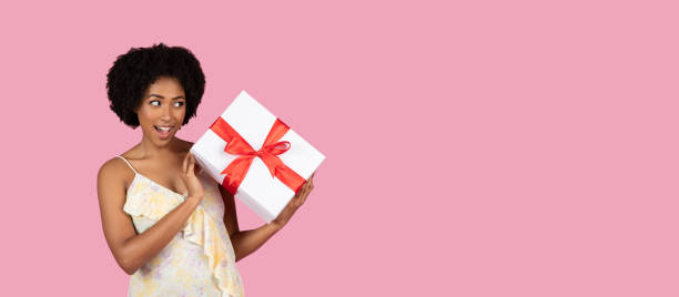 istock Surprised woman holding a gift with white bow 2155546670