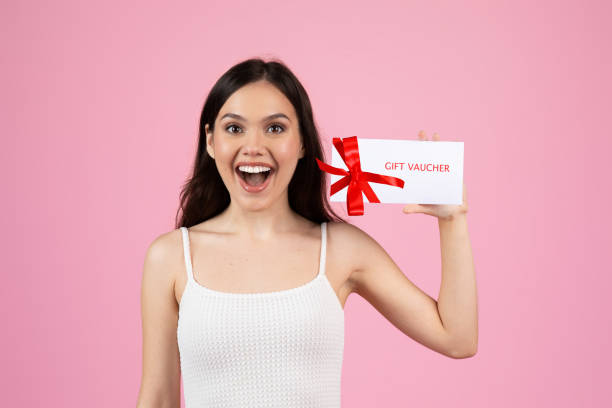 istock Excited woman showing a gift voucher card 2155546702