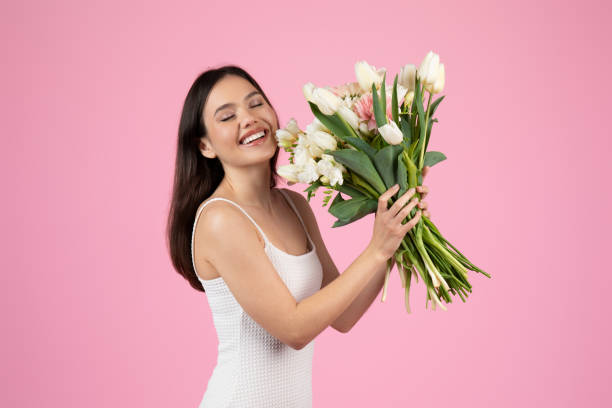 istock Beautiful lady laughing with flowers in hand 2155546720