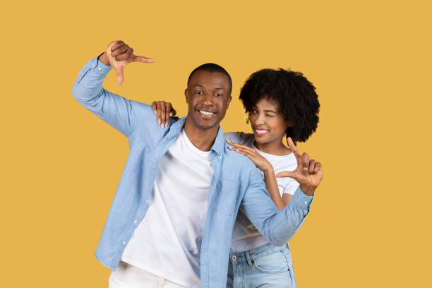 istock Happy couple posing with thumb gestures on yellow 2155546798