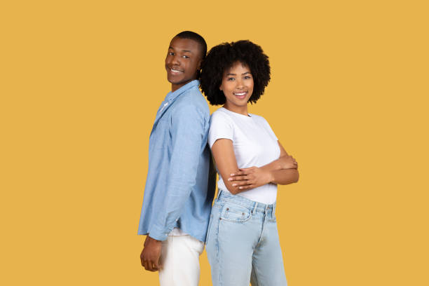istock Happy couple standing back to back on yellow 2155546800
