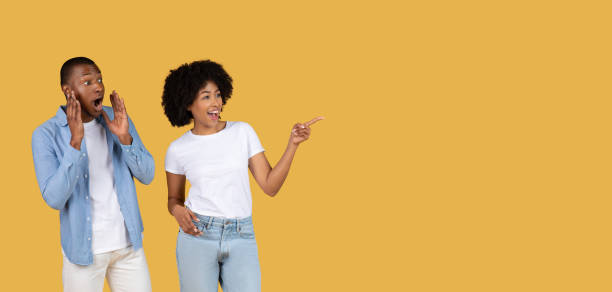 istock Couple pointing and looking surprised at copy space 2155546937