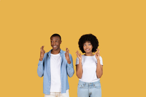 istock Two people making wishful gestures on yellow 2155546943