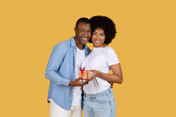 istock Couple holding a gift together and smiling 2155546963