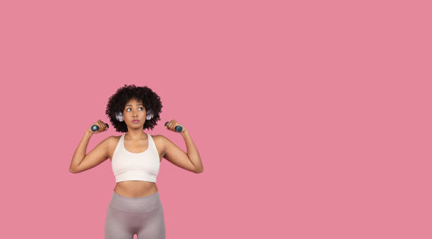 istock Woman lifting dumbbells looking aside 2155547295