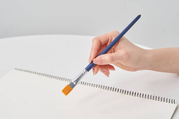 Woman's hand holding a paintbrush