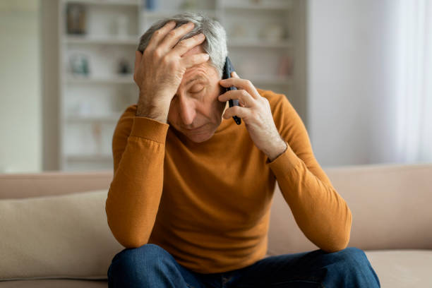 istock Upset senior man have phone conversation at home 2155547389