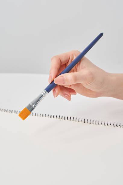 istock Woman's hand holding a paintbrush 2155547424