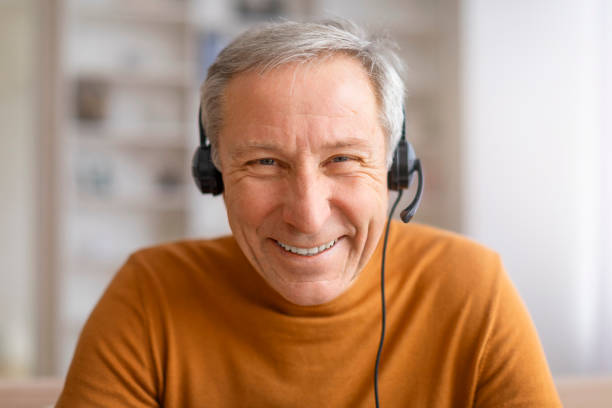 istock Closeup of senior man using headset smiling at camera 2155547434
