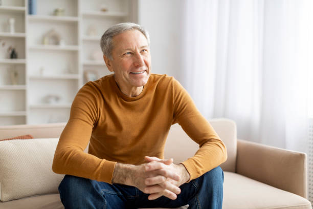istock Mature man smiling while seated indoors, copy space 2155547476
