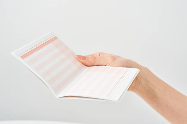 Woman's hand looking at bank passbook and white background