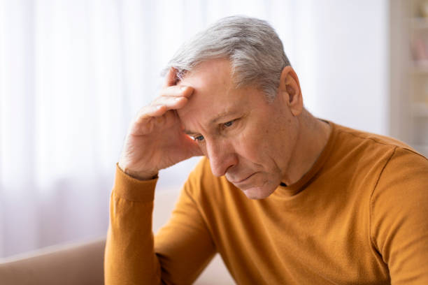 istock Aged man holds forehead in an upset manner 2155547600