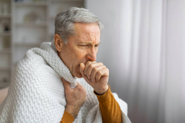 istock Senior man wrapped in blanket looking unwell 2155547642