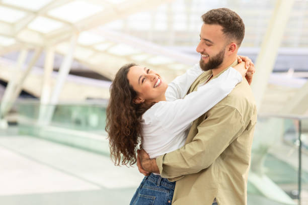 istock Joyful Couple Embracing at Modern Airport Terminal 2155547749