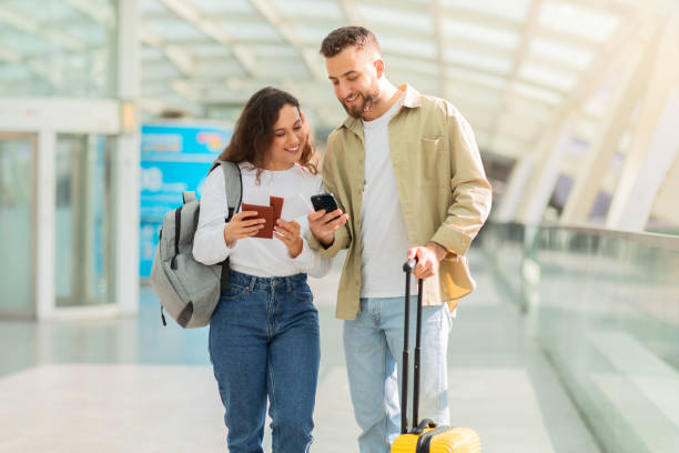 istock Enthusiastic couple with phone and suitcase 2155547775