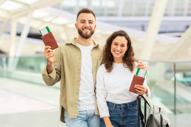 istock Couple smiling with travel documents at airport 2155547784