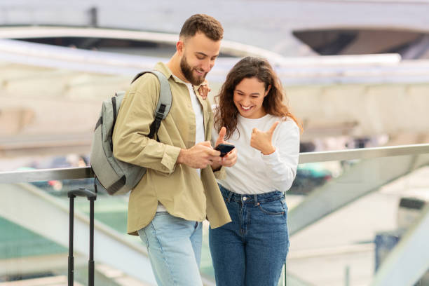 istock Young couple checking content on phone at airport 2155547794