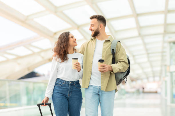 istock Smiling duo holding coffee at transport hub 2155547797