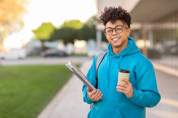 istock Smiling student holding coffee and binders 2155547877