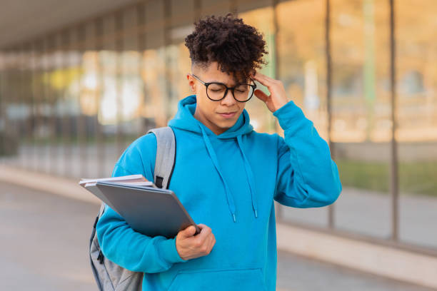 istock Pensive student with notebooks outdoors 2155547888